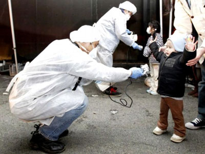 A person examines a japanse baby for radiation